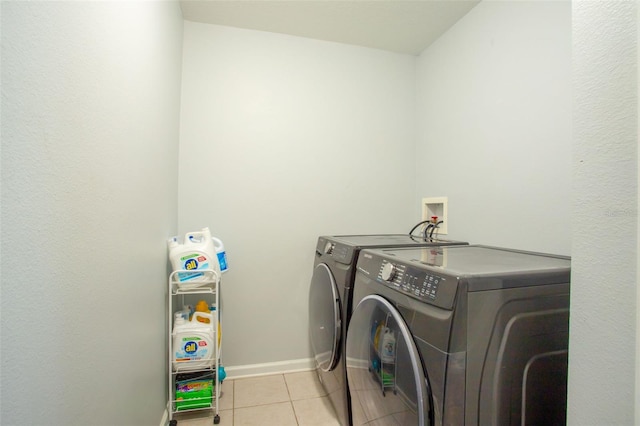 laundry room featuring washing machine and dryer and light tile patterned floors