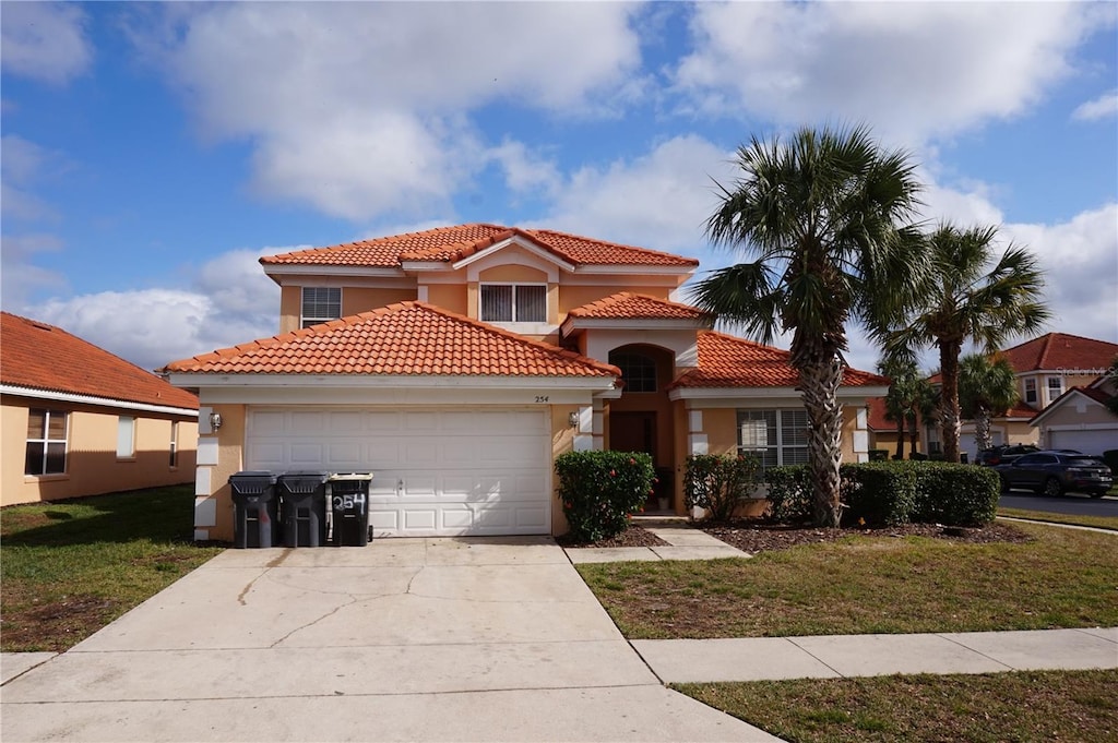 mediterranean / spanish home featuring a front lawn and a garage