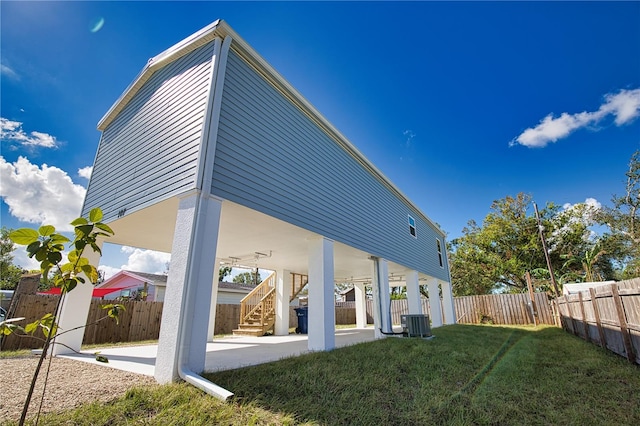 back of property featuring a lawn, cooling unit, and a patio area