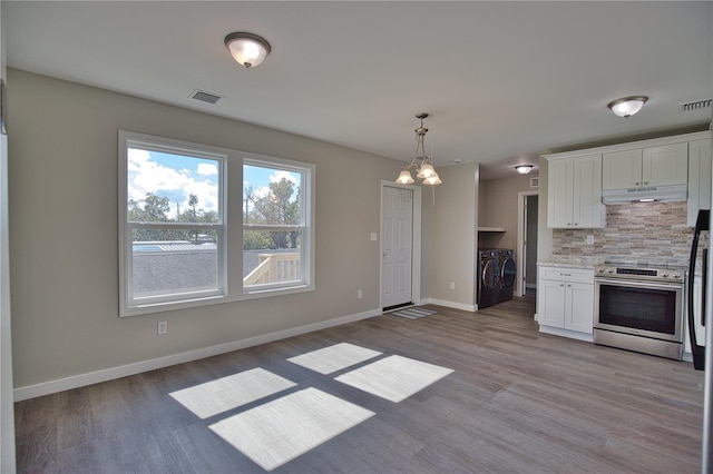 kitchen featuring washing machine and clothes dryer, white cabinetry, stainless steel electric range oven, and light hardwood / wood-style flooring