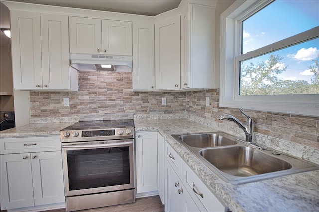 kitchen featuring white cabinets, sink, backsplash, and stainless steel range oven