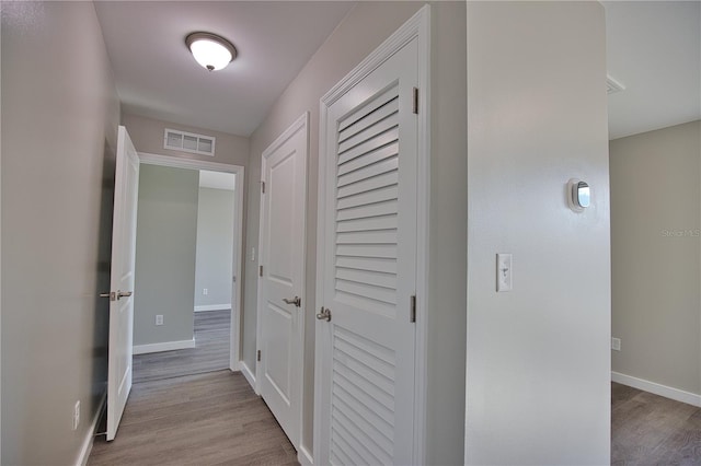 hallway with light hardwood / wood-style floors