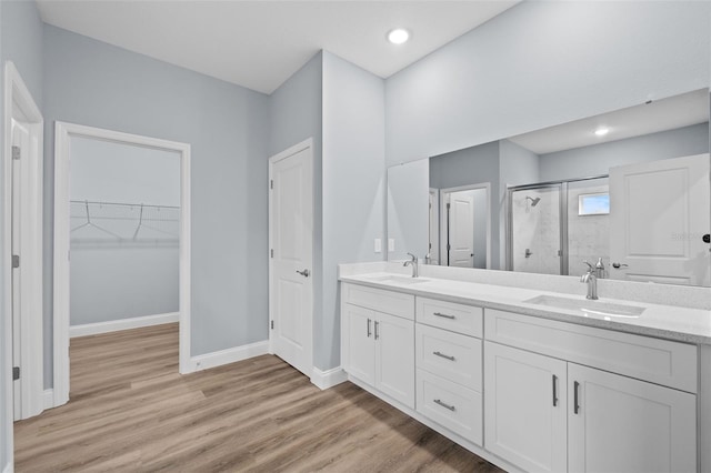 bathroom featuring vanity, hardwood / wood-style flooring, and a shower with shower door