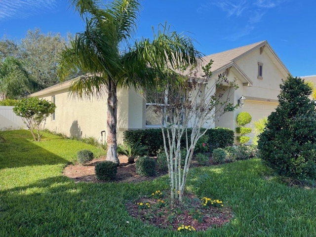 view of property exterior featuring a yard and a garage