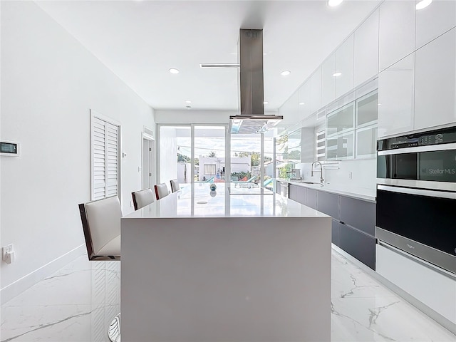 kitchen featuring white cabinetry, a center island, and island range hood