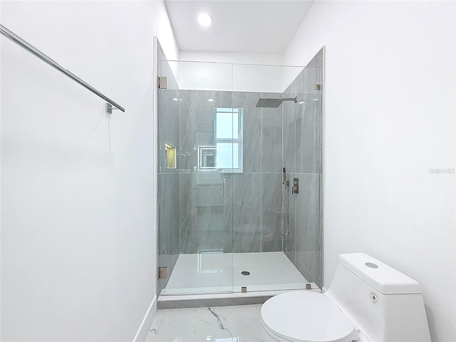 bathroom featuring toilet and a shower with shower door