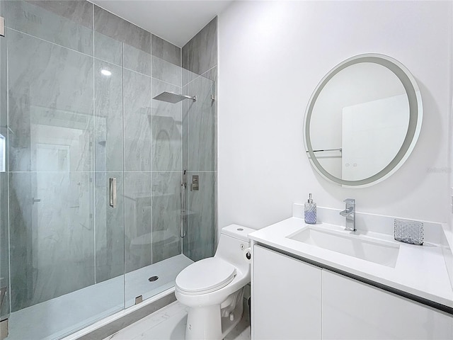 bathroom with vanity, toilet, and a shower with door