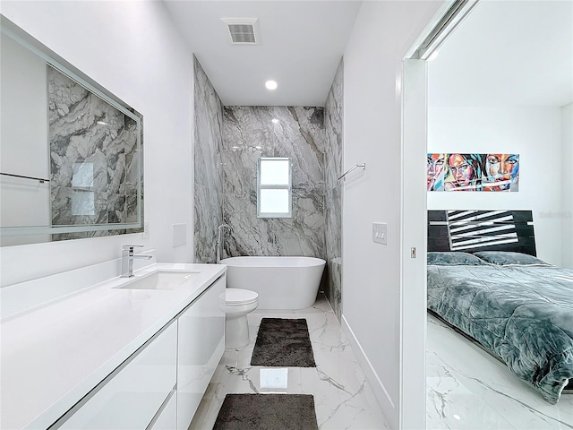 bathroom with a washtub, vanity, and toilet