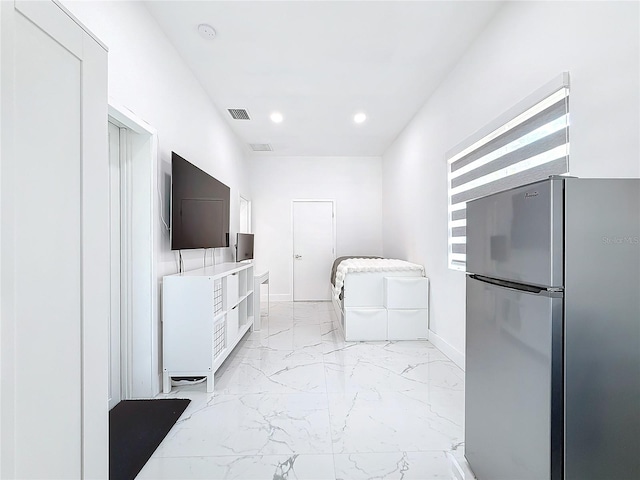 kitchen with white cabinets and stainless steel fridge