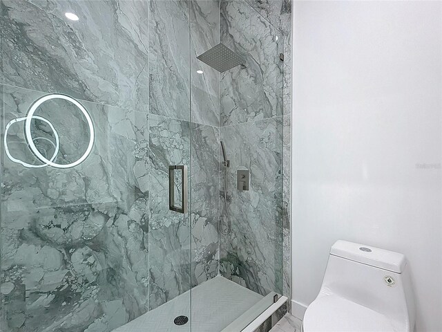 bathroom featuring toilet and tiled shower