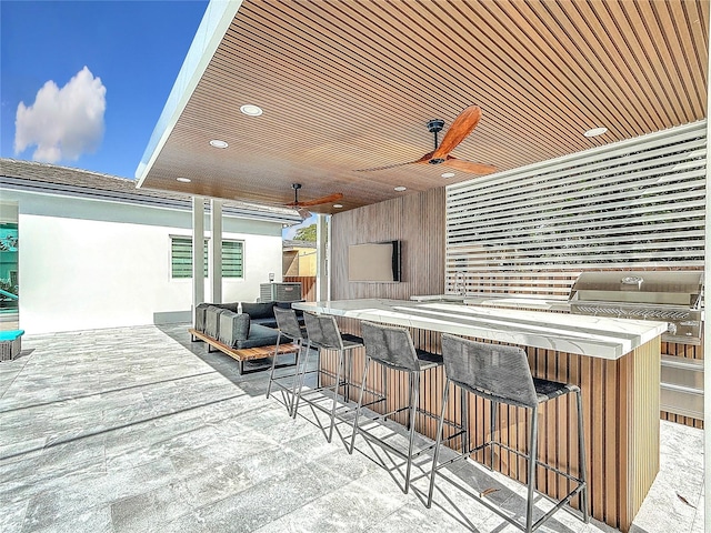 view of patio featuring ceiling fan and a bar