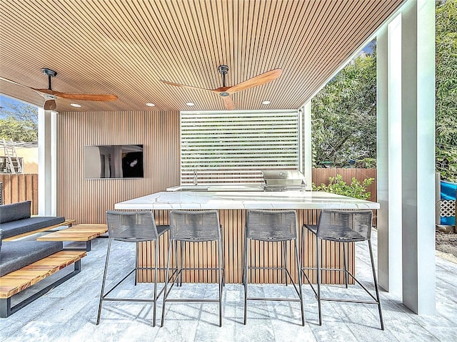 view of patio with ceiling fan and a bar