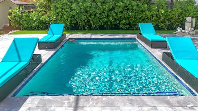 view of pool featuring a yard and a patio