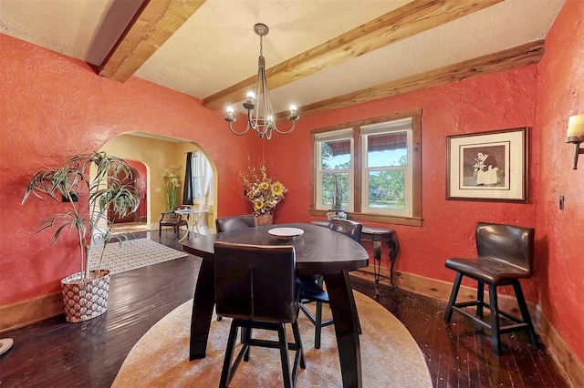 dining space featuring beam ceiling, dark wood-type flooring, and an inviting chandelier