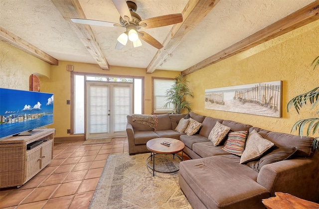 living room with beam ceiling, ceiling fan, french doors, a textured ceiling, and light tile patterned floors