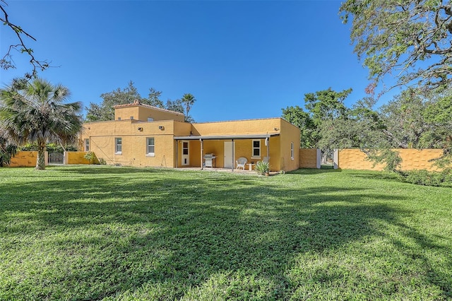 rear view of house featuring a yard