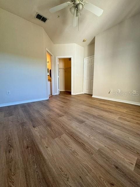 empty room with ceiling fan, dark hardwood / wood-style flooring, and lofted ceiling