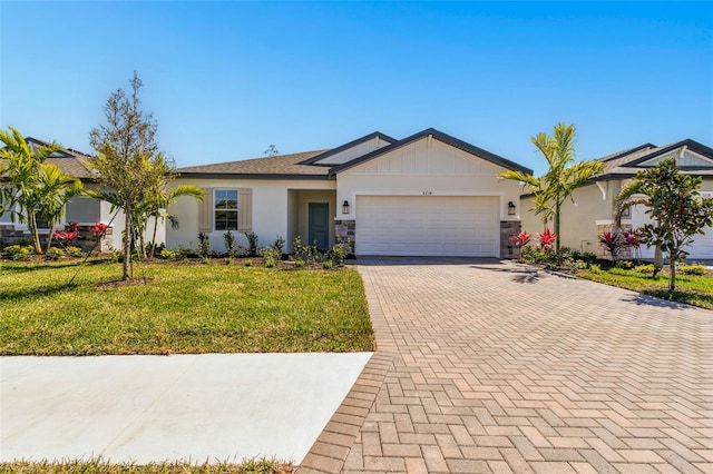 single story home featuring decorative driveway, a front yard, and an attached garage