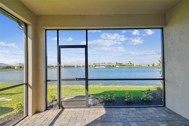 unfurnished sunroom featuring a water view