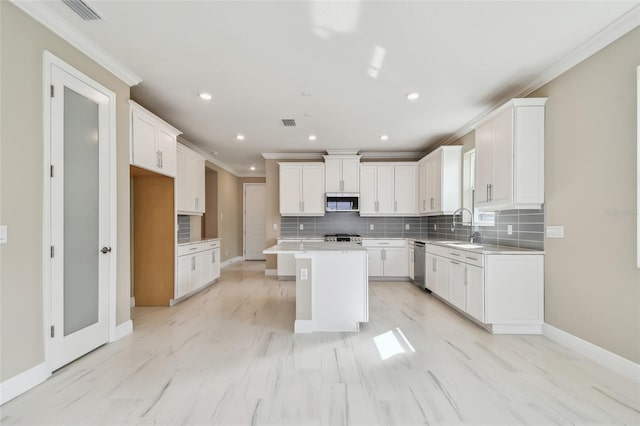 kitchen featuring white cabinetry, sink, a kitchen island, and stainless steel appliances