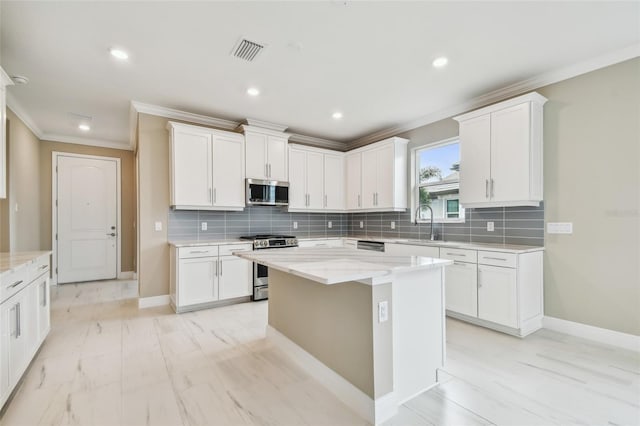 kitchen featuring a center island, light stone counters, white cabinetry, and appliances with stainless steel finishes