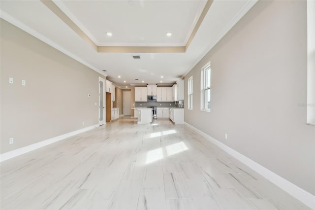 unfurnished living room with a tray ceiling