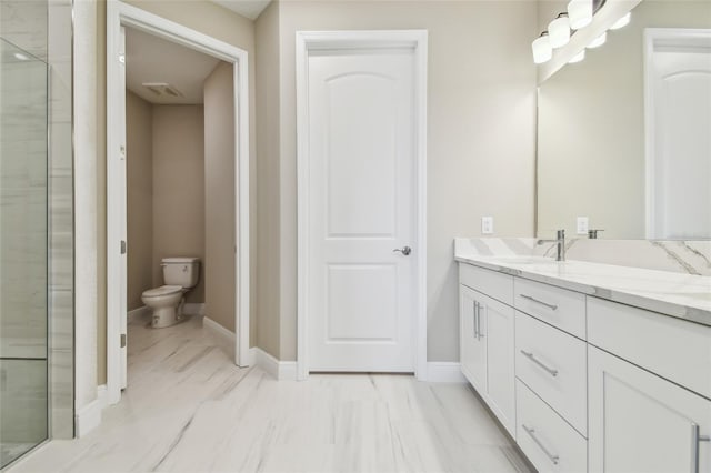 bathroom featuring a shower with door, vanity, and toilet