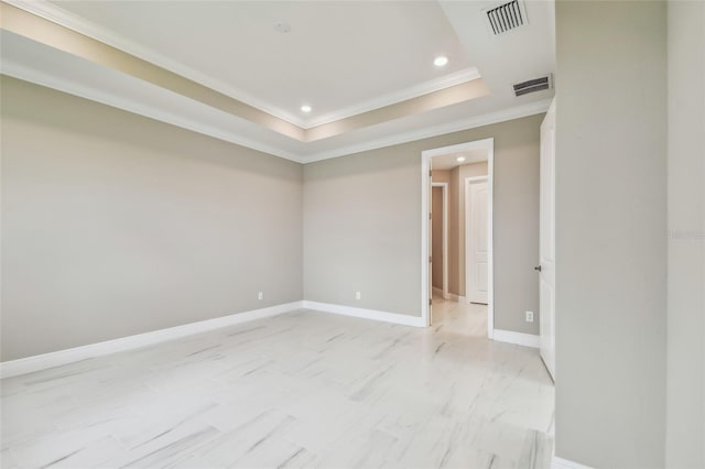 spare room featuring a raised ceiling and ornamental molding