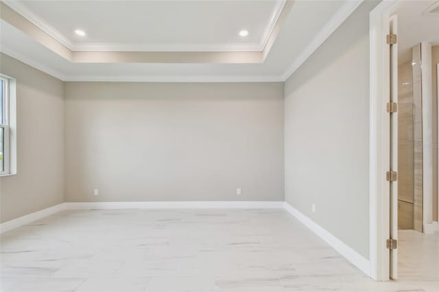 empty room featuring a raised ceiling and crown molding