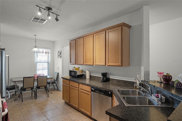 kitchen featuring a textured ceiling, sink, light tile patterned floors, decorative light fixtures, and dishwasher