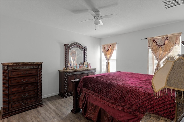 bedroom featuring multiple windows, ceiling fan, a textured ceiling, and light wood-type flooring