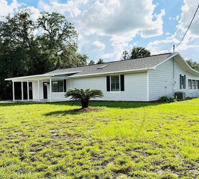 back of property with a yard and central air condition unit