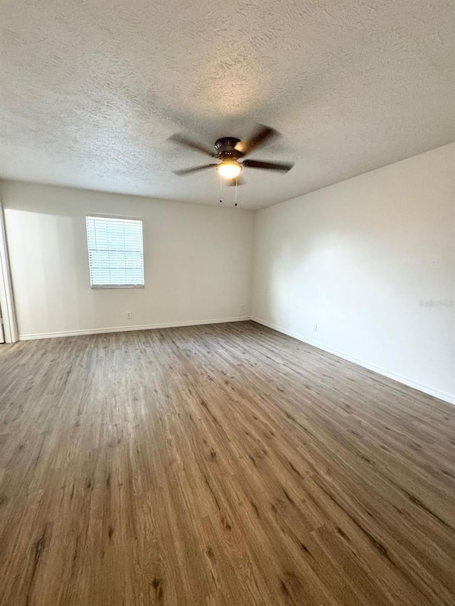 spare room featuring hardwood / wood-style floors, ceiling fan, and a textured ceiling