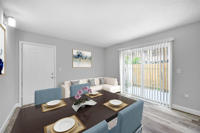 dining space featuring a textured ceiling and light hardwood / wood-style flooring