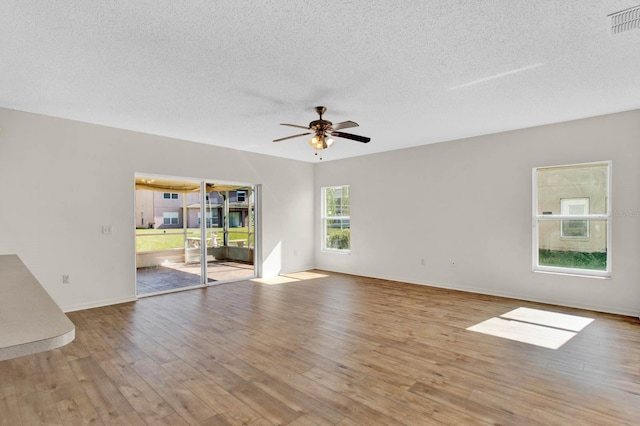 spare room featuring ceiling fan, light hardwood / wood-style floors, and a textured ceiling