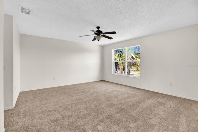 carpeted spare room featuring ceiling fan and a textured ceiling