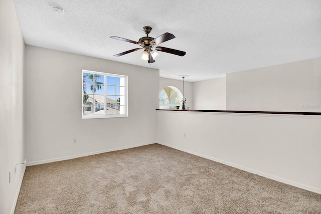 empty room with ceiling fan, carpet, and a textured ceiling