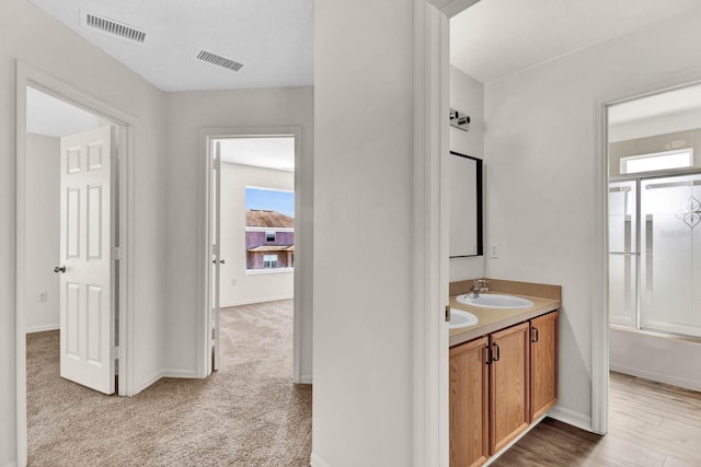 bathroom with vanity, combined bath / shower with glass door, and hardwood / wood-style flooring