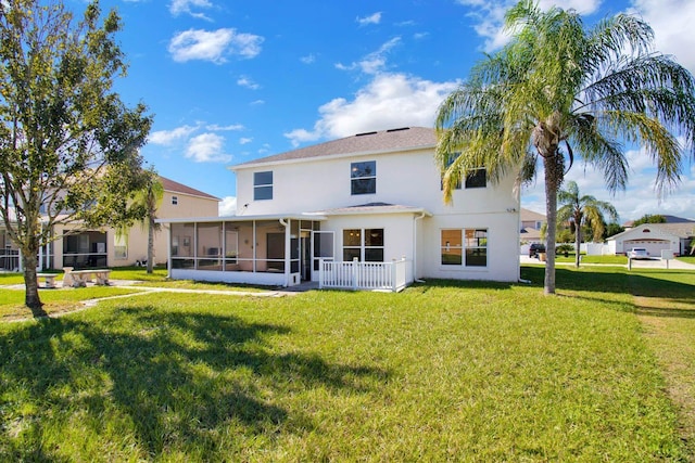 rear view of property with a sunroom and a yard