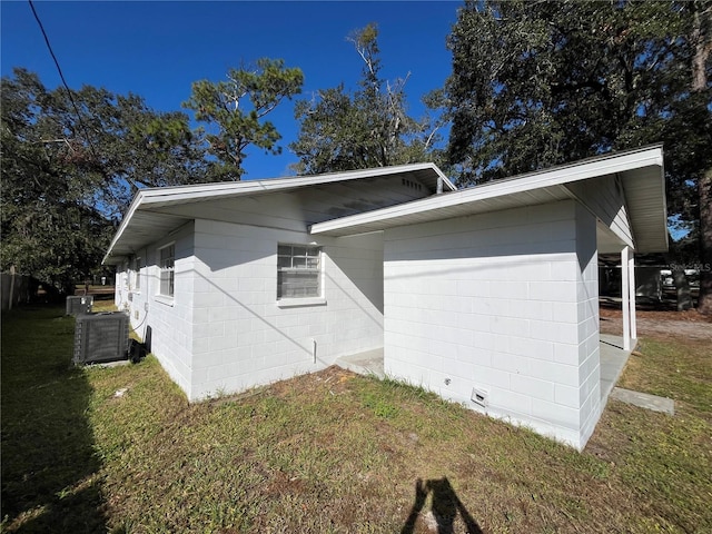 view of side of property featuring cooling unit and a lawn