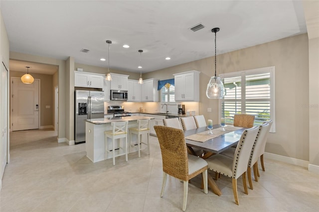 dining space featuring light tile patterned flooring and sink