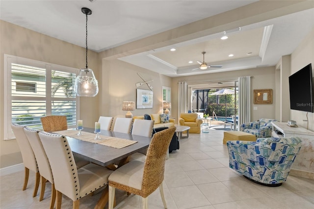 dining room with ceiling fan, light tile patterned floors, and a tray ceiling