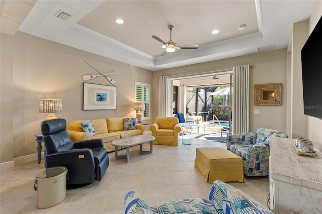 living room with light tile patterned floors, a raised ceiling, and ceiling fan