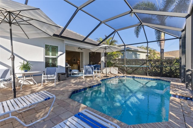 view of swimming pool featuring a lanai, ceiling fan, and a patio area