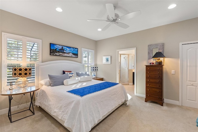 carpeted bedroom with ceiling fan and ensuite bath