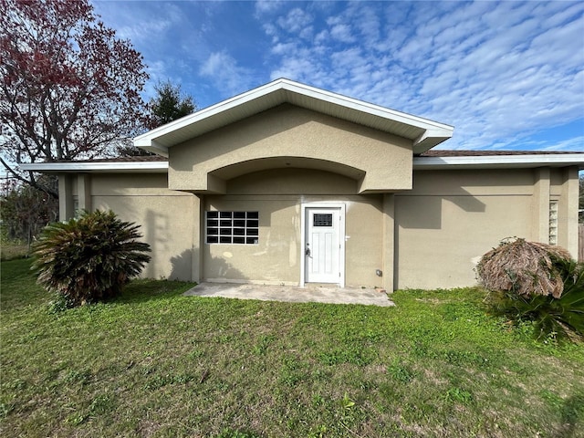 entrance to property featuring a lawn