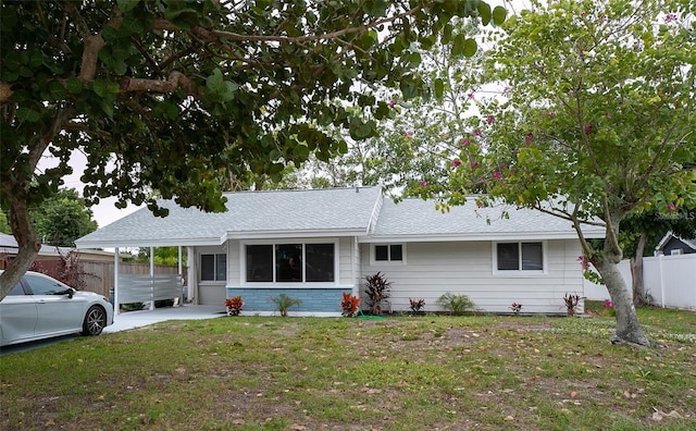 ranch-style house with a carport and a front lawn