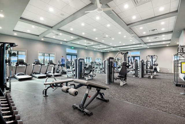 workout area featuring ceiling fan, a towering ceiling, and coffered ceiling