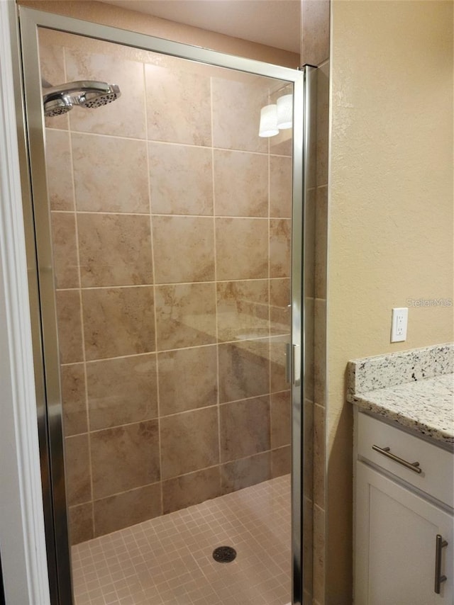 bathroom with vanity and a shower with door