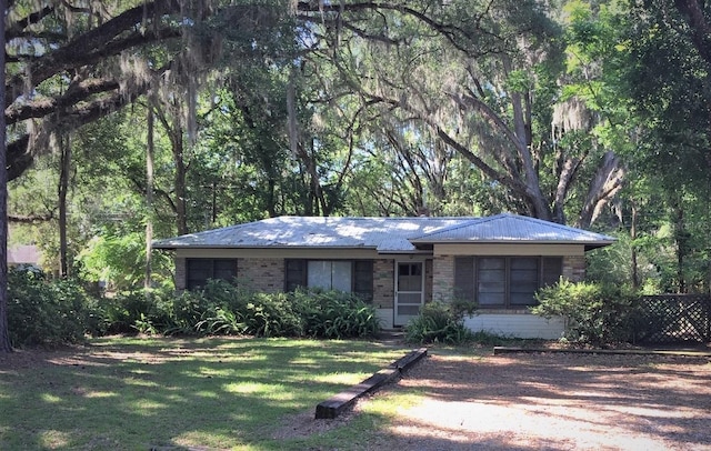 single story home featuring a front lawn